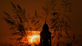 A solar eclipse is seen over a Virgin Maria church in Vidigulfo, near Pavia, northern Italy