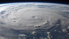 Zachwycający widok Ziemi z lotu ptaka z ogromnym wirującym huraganem, ukazujący piękno zjawisk meteorologicznych.