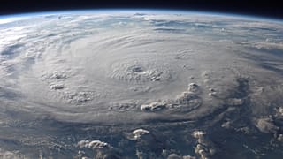 A stunning aerial view of Earth with a massive swirling hurricane, highlighting meteorological beauty