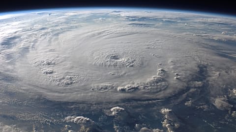 A stunning aerial view of Earth with a massive swirling hurricane, highlighting meteorological beauty