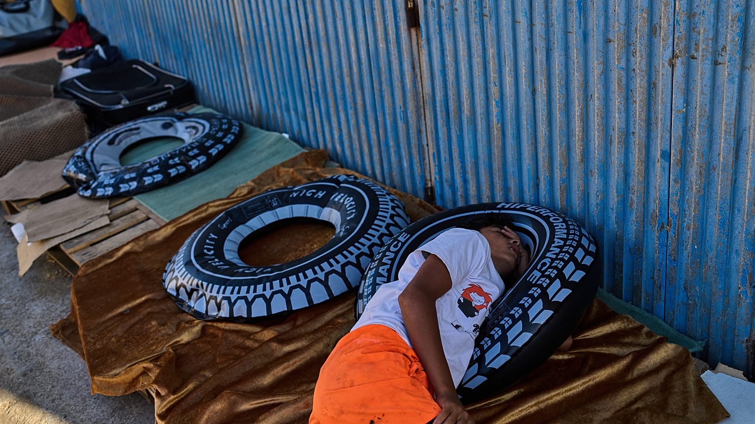 Sufian, un menor no acompañado de 13 años procedente de Marruecos, duerme en una zona de almacenes cerca de la frontera entre España y Marruecos, en el enclave de Ceuta