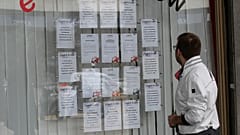 صورة أرشيفية: في هذه الصورة التي التقطت يوم الاثنين، 2 أبريل 2012، ينظر شاب إلى إعلان وظيفة معروض في واجهة مكتب توظيف في ميلانو بإيطاليا