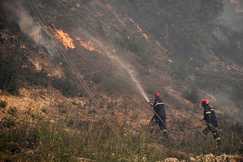 Firefighters work to extinguish a wildfire in Siviri, 13 August, 2026
