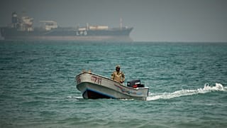 جندي يمني يبحر في المياه شمال مضيق باب المندب قبالة مدينة المخا، فيما تظهر في الخلفية ناقلة غاز بترولي مسال، 6 أبريل/نيسان 2026.