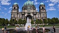 Angesichts steigender Temperaturen in Berlin erfrischen sich Menschen am Donnerstag, dem 30. Juli 2026, in einem Springbrunnen vor dem Dom. (AP Photo/Ebrahim Noroozi)