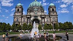 As temperatures rise in Berlin, people cool off in a fountain in front of the cathedral on Thursday 30 July 2026. (AP Photo/Ebrahim Noroozi)
