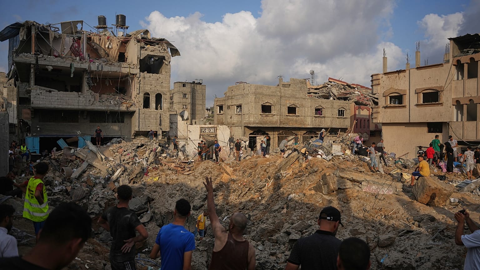 فلسطينيون يتفقدون المباني المدمرة في موقع غارة جوية إسرائيلية على مخيم المغازي للاجئين وسط قطاع غزة، الجمعة 24 يوليو 2026.