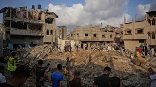 فلسطينيون يتفقدون المباني المدمرة في موقع غارة جوية إسرائيلية على مخيم المغازي للاجئين وسط قطاع غزة، الجمعة 24 يوليو 2026.