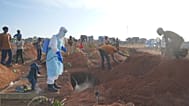 A health worker sprays disinfectant in a freshly dug grave in Bunia, 12 August, 2026