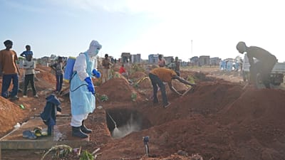 A health worker sprays disinfectant in a freshly dug grave in Bunia, 12 August, 2026