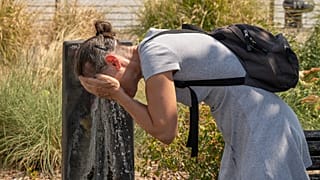 Una donna si sciacqua il viso a una fontana pubblica in una calda giornata a Bordeaux, il 13 agosto 2026, mentre un'ondata di caldo colpisce gran parte del Paese.