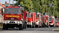Symbolbild: Feuerwehrleute am  26. Juli 2022 in einem Konvoi am Ort eines Waldbrands in der Nähe von Falkenberg in Deutschland