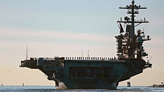 Sailors and Marines line the deck of aircraft carrier USS Abraham Lincoln (CVN-72) as it deploys from San Diego, Jan. 3, 2021.