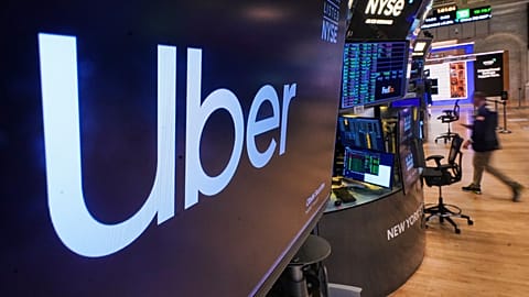 The logo for Uber is displayed above a trading post on the floor of the New York Stock Exchange, Monday, Oct. 20, 2025.