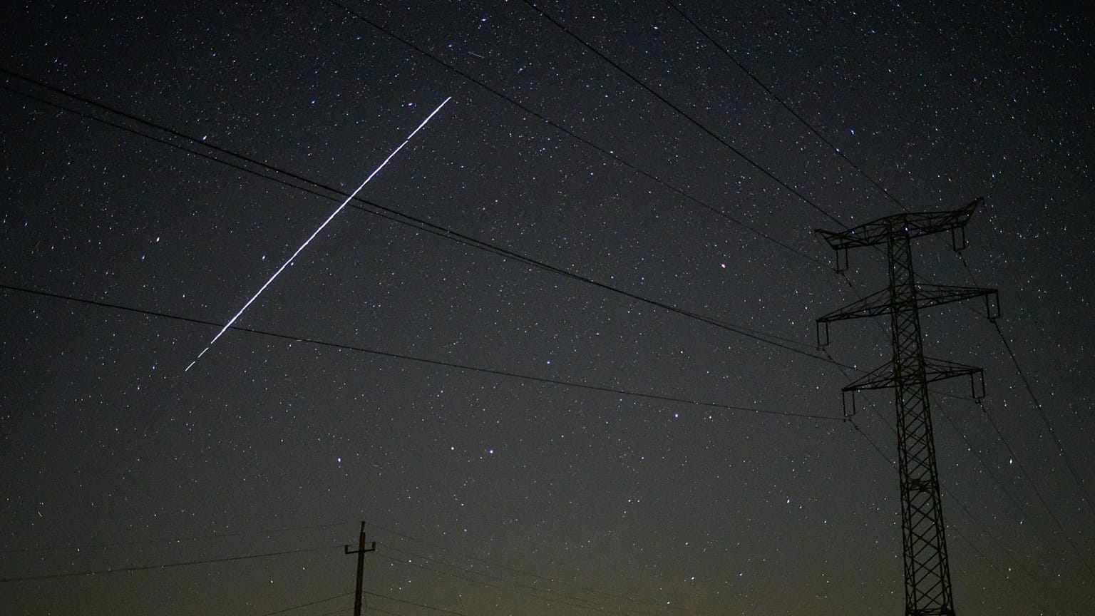ΑΡΧΕΙΟ - Μια συστοιχία δορυφόρων Starlink της SpaceX περνά πάνω από το Σαλγοταριάν, Ουγγαρία, τις πρώτες ώρες της 12ης Μαΐου 2021.