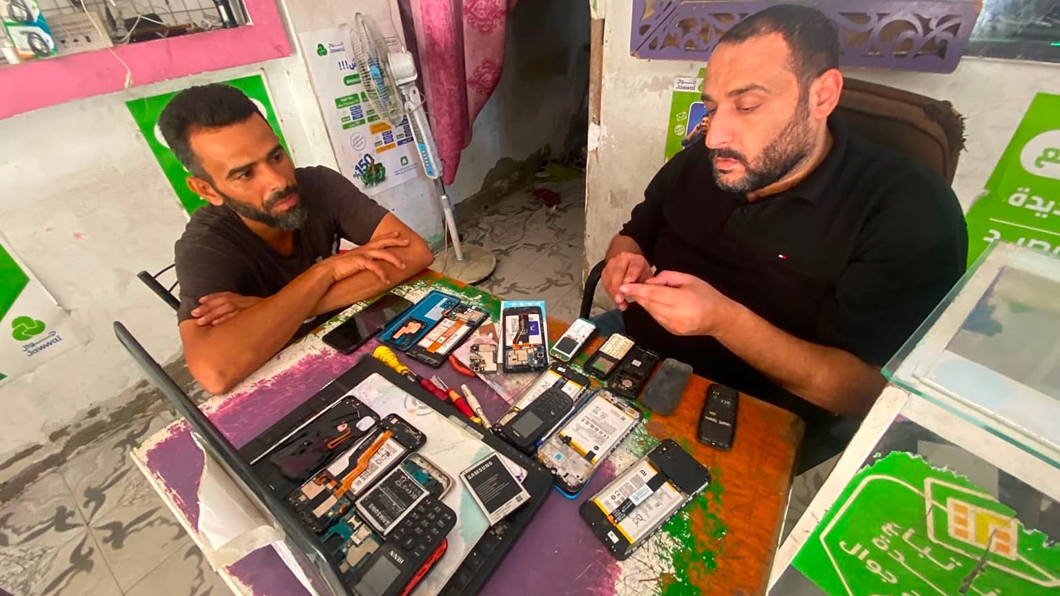 عادل الكتري صاحب محل إصلاح الهواتف النقالة في مخيم النصيرات بدير البلح بقطاع غزة 