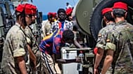 Un migrante recoge agua distribuida por soldados españoles en el enclave español de Ceuta, el domingo 2 de agosto de 2026.