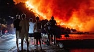 People look at a wildfire on the Adriatic coast near Omiš, 14 August, 2026