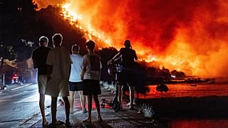 People look at a wildfire on the Adriatic coast near Omiš, 14 August, 2026