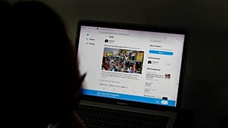 امرأة تنظر إلى صفحة نجمة البوب ريهانا على تويتر