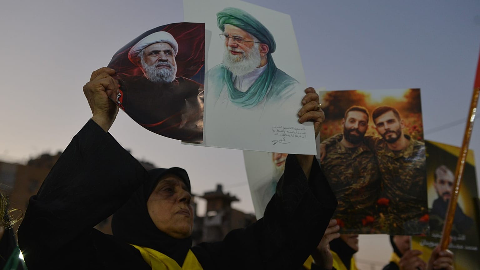 سيدة تحمل صور نعيم قاسم والمرشد الإيراني الراحل علي خامنئي خلال تجمع في الضاحية الجنوبية لبيروت، بالتزامن مع جنازته الأربعاء 8 يوليو 2026