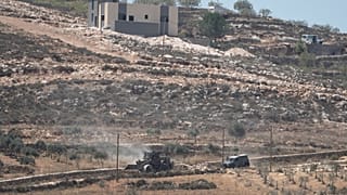 مركبات تابعة للجيش الإسرائيلي تعمل بالقرب من منازل فلسطينية يحاصرها مستوطنون إسرائيليون في قرية قصرة المحتلة بالضفة الغربية جنوب نابلس
