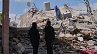 سيدتان تقفان على أنقاض منزلهما الذي دمّرته غارة إسرائيلية في بلدة دير قانون النهر، جنوب لبنان. يوم الاثنين 15 حزيران/يونيو 2026.