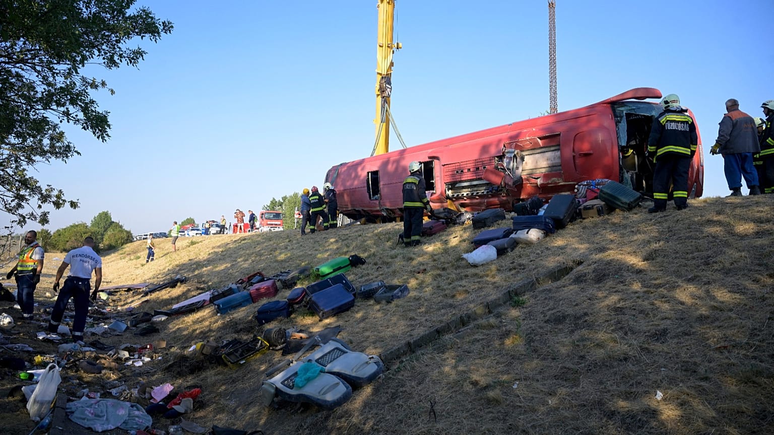 Emergency services attend the scene after a passenger bus went off the road and overturned in a ditch along a highway in Hungary, 16 August, 2026