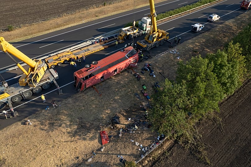 Emergency services attend the scene after a passenger bus went off the road and overturned in a ditch along a highway in Hungary, 16 August, 2026