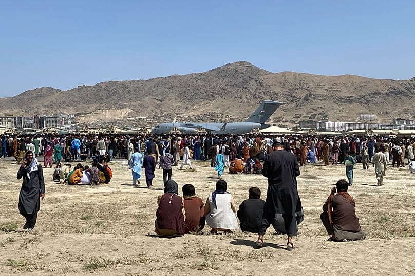 Hundreds gather near a US military transport plane at the international airport in Kabul as the US withdraws in 2021