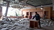 A worker removes a broken furniture inside a room at the local government office which was damaged during an earthquake in Ruteng, East Nusa Tenggara province, Indonesia, Sund