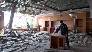 A worker removes a broken furniture inside a room at the local government office which was damaged during an earthquake in Ruteng, East Nusa Tenggara province, Indonesia, Sund