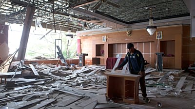 Un operaio rimuove mobili danneggiati da una stanza dell'ufficio del governo locale colpito da un terremoto a Ruteng, nella provincia di East Nusa Tenggara, Indonesia.