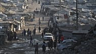 فلسطينيون يسيرون بين الخيام وأنقاض المباني التي دمرت خلال الحرب بين إسرائيل وحماس على طول الطريق الساحلي في مدينة غزة، الخميس 13 أغسطس 2026.
