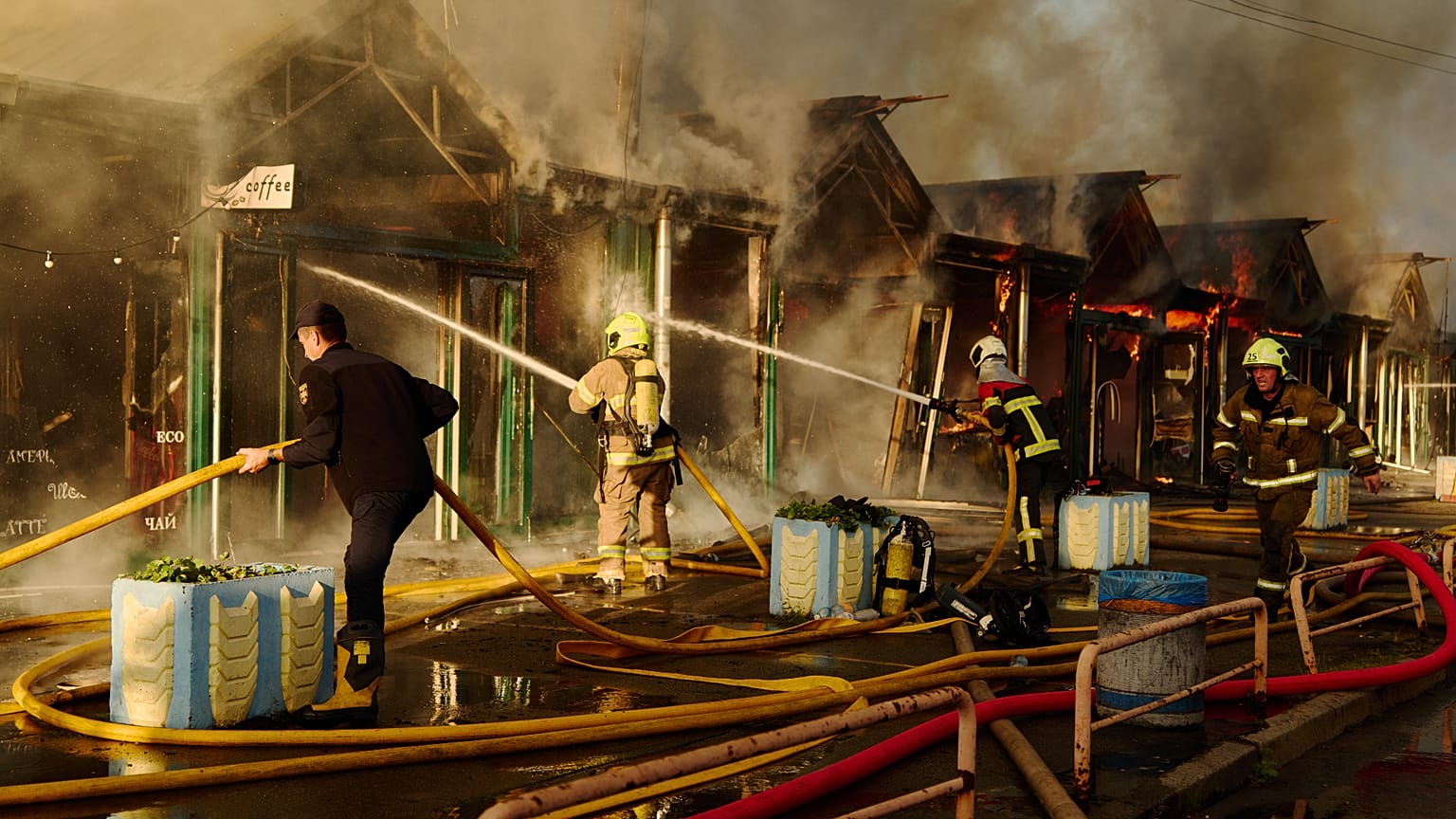 Firefighters try to put out a fire following a Russian missile attack in Kyiv