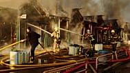 Firefighters try to put out a fire following a Russian missile attack in Kyiv