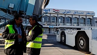 عاملون على مدرج مطار دمشق خلال استئناف الرحلات الداخلية، في 18 كانون الأول 2024.
