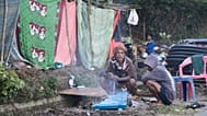 Earthquake survivors make fire to warm themselves outside their makeshift tent in Reo, 17 August, 2026