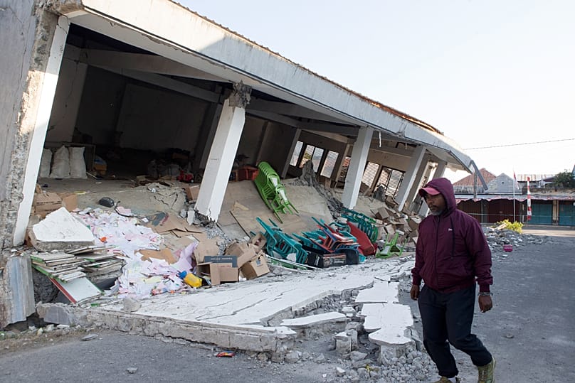 A man walks building collapsed during an earthquake in Reo, 17 August, 2026
