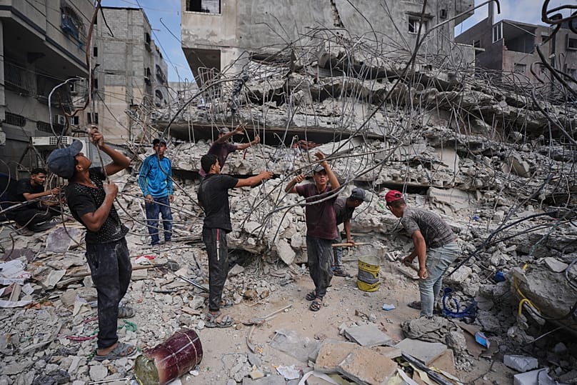 Palestinians remove iron from the rubble of buildings destroyed by Israeli air strikes in Gaza City, 16 August, 2026