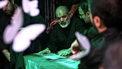 أحمد وحيدي من الحرس الثوري الإيراني شبه العسكري إلى جانب نعش المرشد الأعلى الإيراني آية الله علي خامنئي وهو يرقد في قاعة حداد مجاورة للإمام الخميني الحسينية داخل مجمع المرشد 