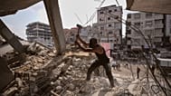 فلسطينيون يزيلون الحديد من تحت أنقاض المباني التي دمرتها الغارات الجوية الإسرائيلية خلال الحرب مع حماس، ويصلحونه ويعيدون تدويره للبناء أو بناء الخيام أو بيعه