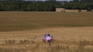 Egy ember esernyőt tartva száraz fűben sétál a wiltshire-i Stonehenge-nél, Angliában, 2026. augusztus 13-án, csütörtökön. (AP Photo/Kin Cheung)