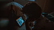Criança pequena a ver um tablet à noite.
