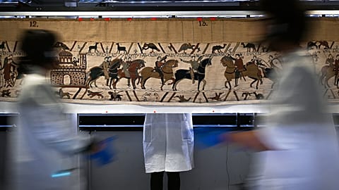 Workers and volunteers prepare to pack the Bayeux tapestry to transfer to the British Museum