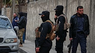 صورة تعبيرية- عناصر من قوات الأمن التابعة للحكومة السورية يقفون بالقرب من مركز للشرطة في بلدة جرمانا