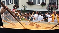 Kucharze mieszają jajka podczas 22. edycji święta wielkiego omletu w Malmedy w Belgii, 15 sierpnia 2017 r.