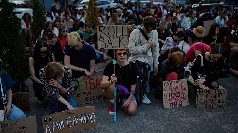 People hold a minute of silence during a rally to protest the dismissal of Mykhailo Fedorov as Ukraine's Defense Minister in Kyiv, Friday, Aug. 14, 2026. 