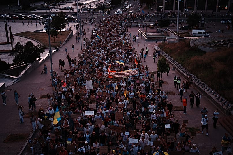 People march during a rally to protest the dismissal of Mykhailo Fedorov as Ukraine's Defense Minister in Kyiv, late Sunday, Aug. 16, 2026. 