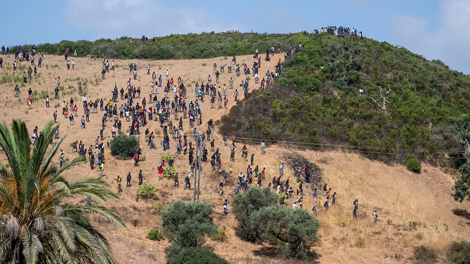 Un grupo de migrantes se reúne en una colina mientras intentan cruzar desde la localidad fronteriza de Fnideq hacia el enclave español de Ceuta, el sábado 15 de agosto de 2026
